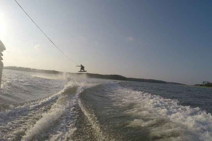 a man flying through the air while riding a snowboard down a dirt road