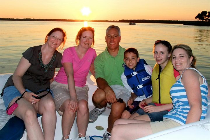 Christine McGlade et al. sitting on a boat posing for the camera